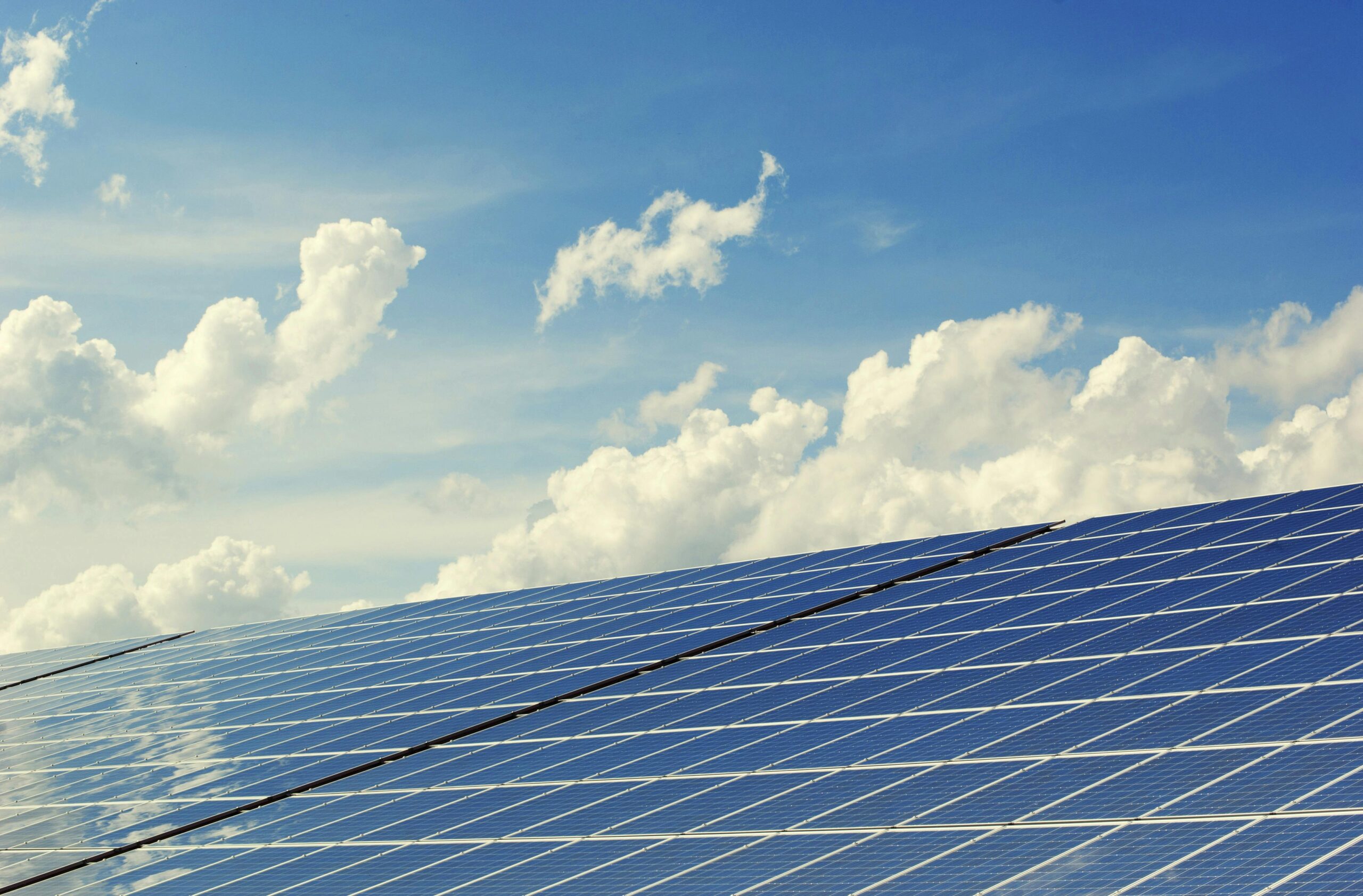pexels-photo-356036-356036 | Architettura Maharishi Vastu Sleek modern solar panels under a vibrant blue sky with clouds, symbolizing clean energy.
